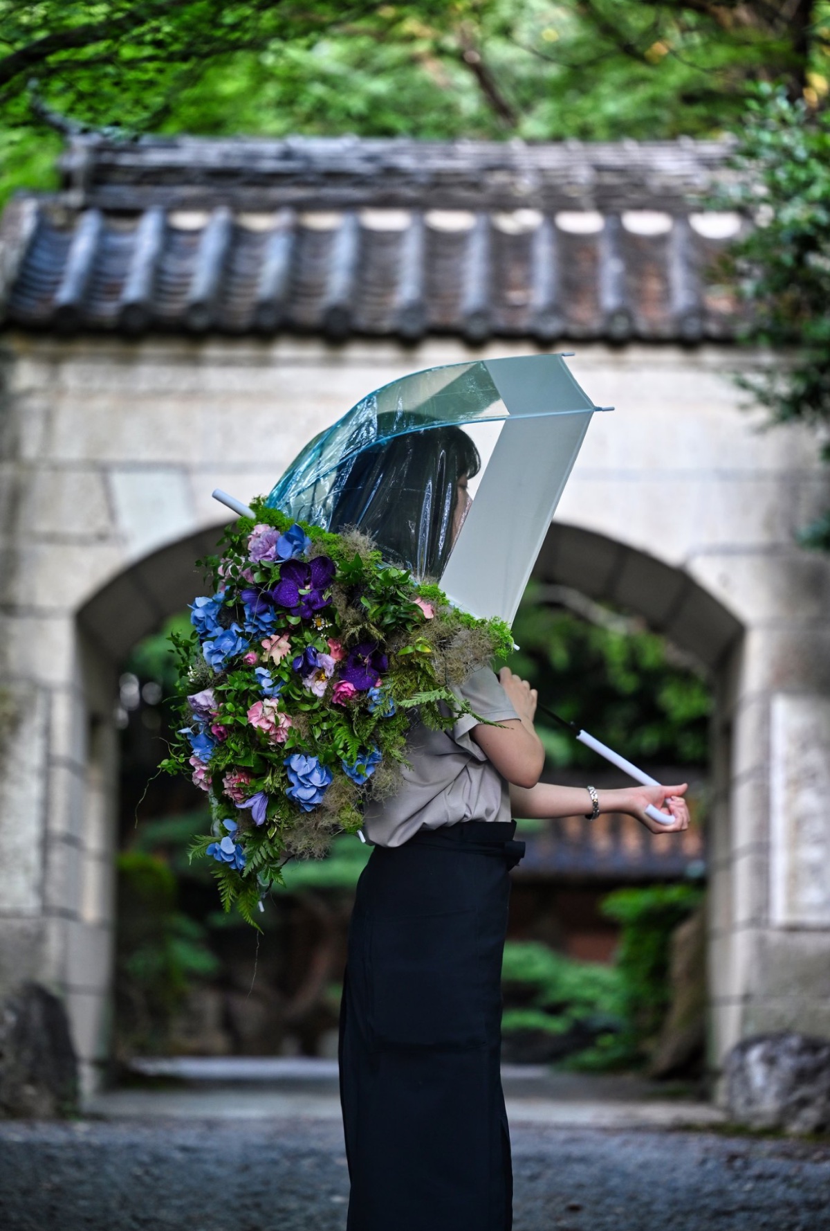 花を纏う造形作品と透明な傘